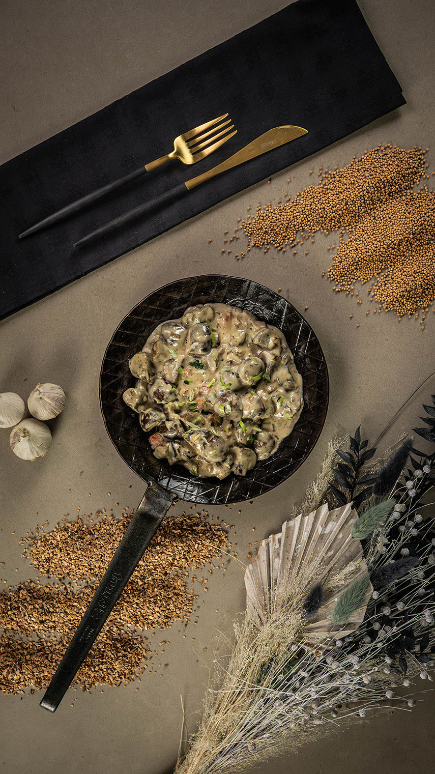 Rezept Pilzrahm Pfanne mit Kräuter Senf, Knoblauch Oel und Pfeffer in einer Eisenpfanne.