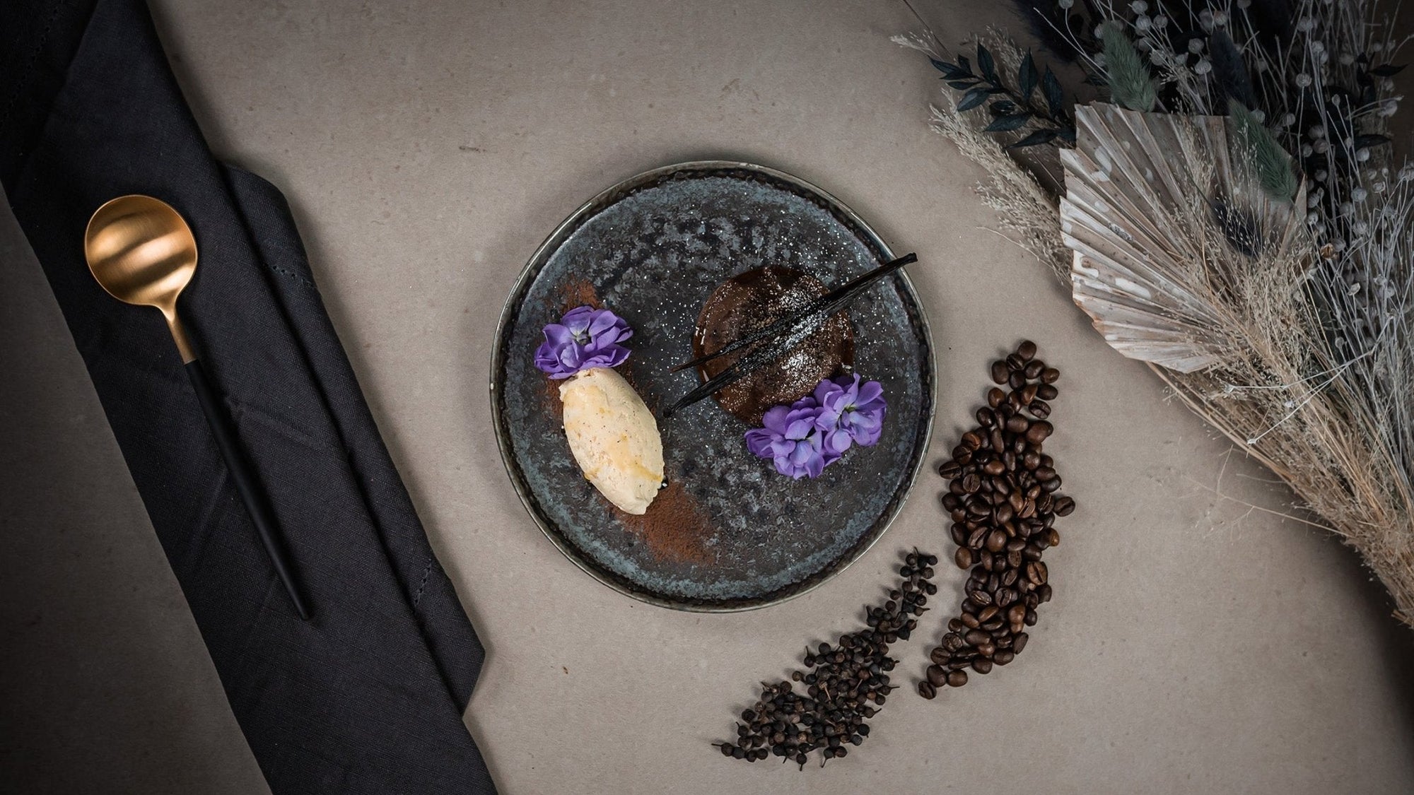 Soufflé de Chocolate mit Kaffeeöl und serviert mit einer Kugel Vanilleeis und einer Vanille Schote.