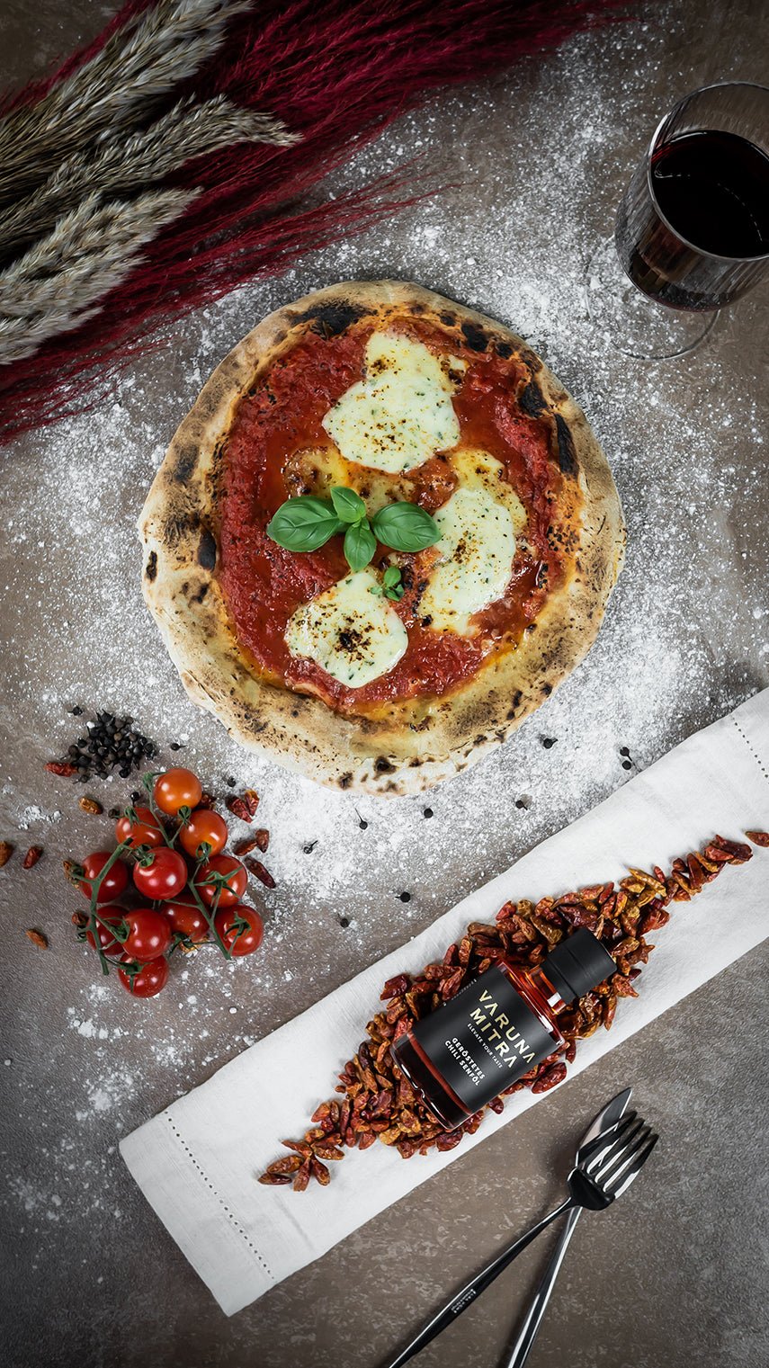Geröstetes Chili Würzöl mit Pizza Margherita und Rotwein von oben fotografiert