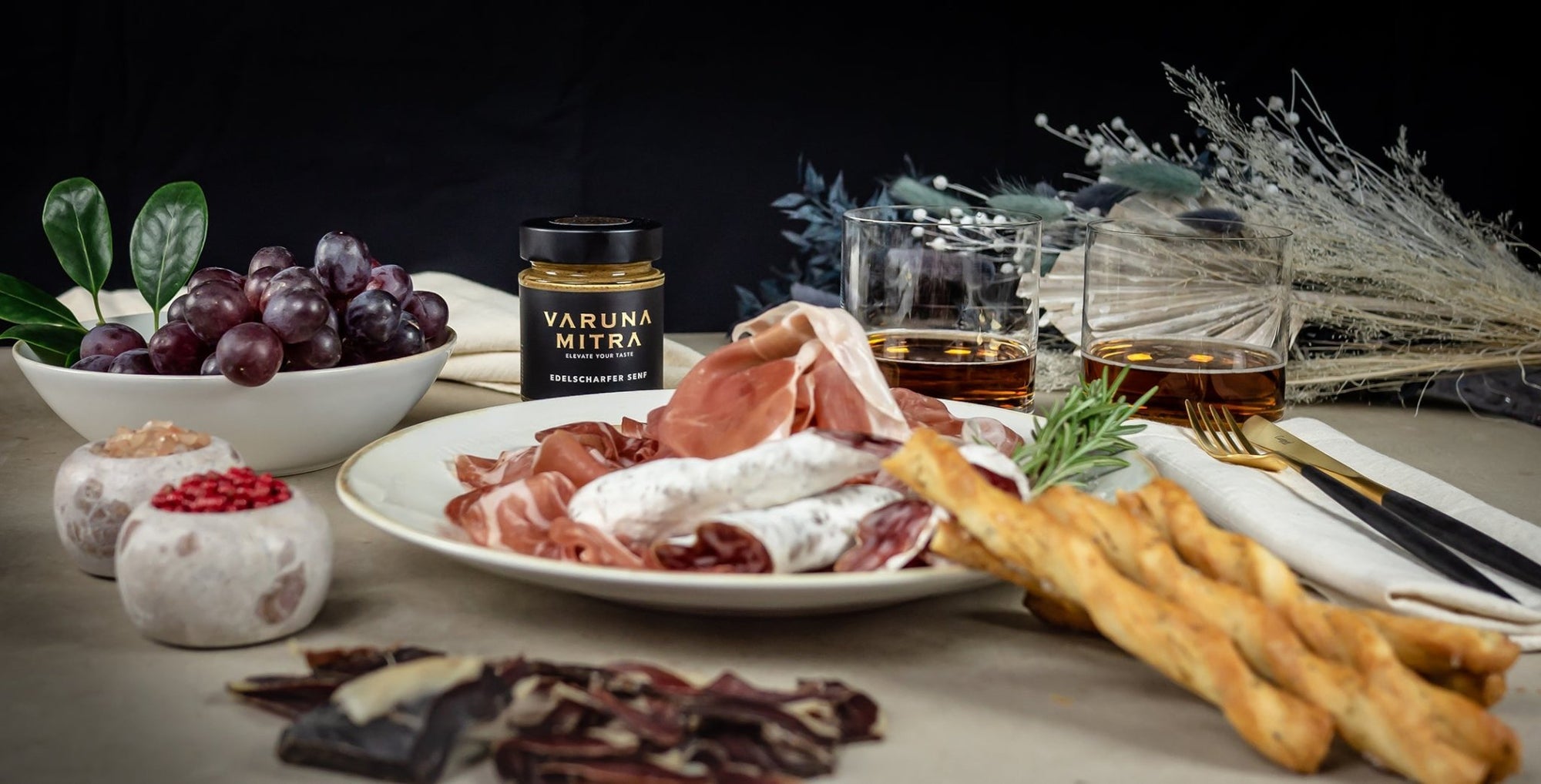 Scharfer Senf mit einem Teller Tapas, Brotstangen, Trauben und Whisky