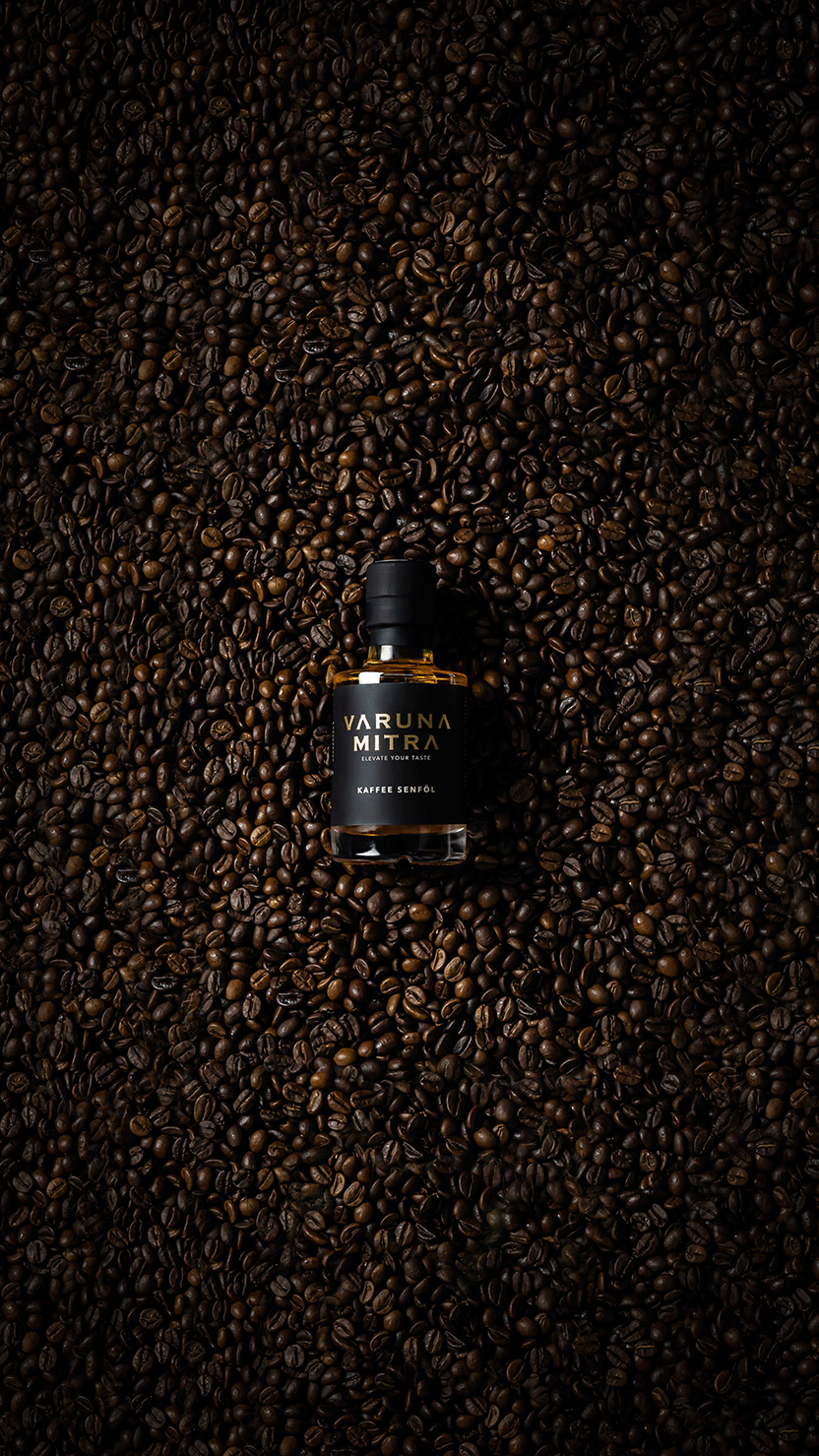 Eine Flasche Kaffee Senföl Würzöl liegend auf einem Meer von Kaffeebohnen