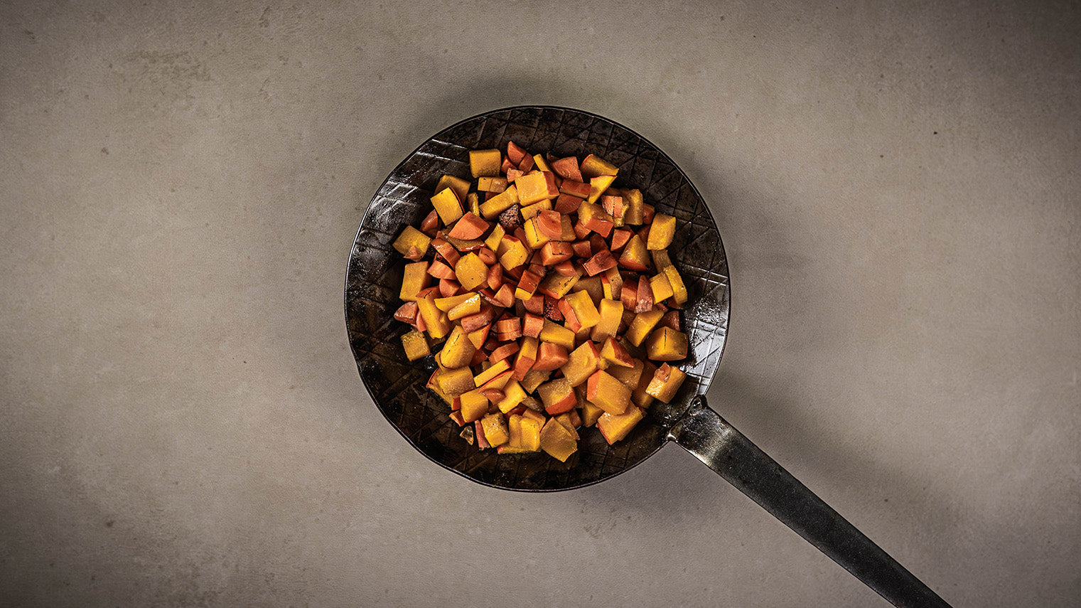 Kürbis Würfel angebraten in Gusspfanne.