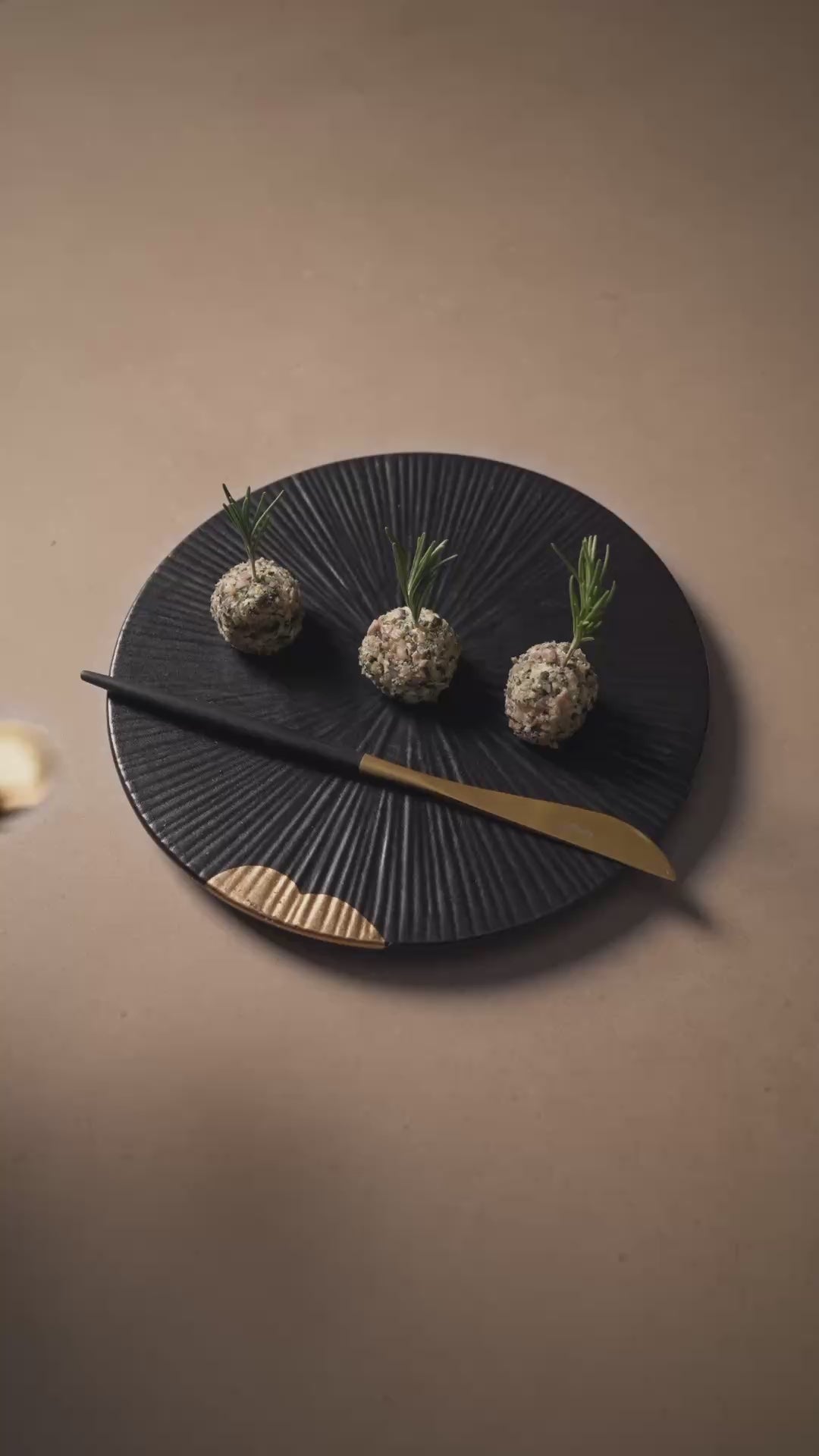 Rezept Ziegenkäse Balls mit Zitronen Senf auf einem schwarzen Teller auf hellem Stein.