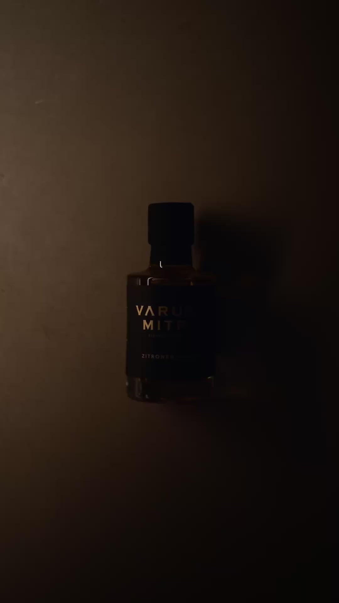 Varuna Mitra Zitronen Senföl Flasche auf beigem Hintergrund mit Lichtspiel.
