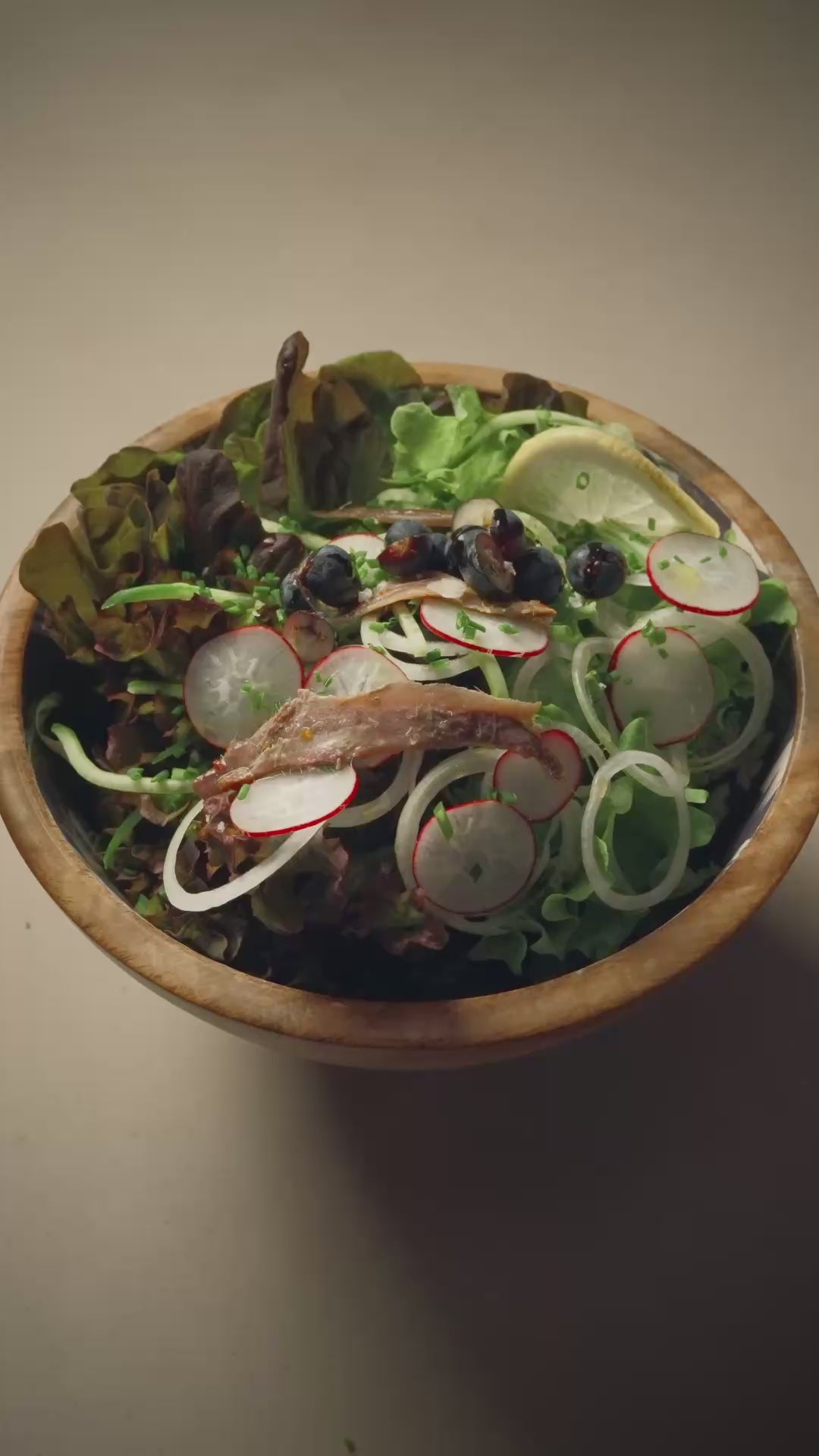 Rezeptidee frischer Salat mit kaltgepresstem Kapernöl, Sardellen, Radieschen und Blaubeeren.