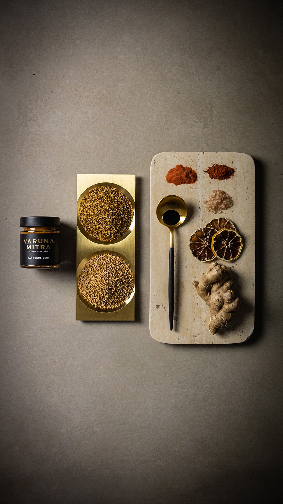 Varuna Mitra Barbecue Grillsenf mit Senfsaat in einer goldenen Schale, neben Ingwer, Zitronen, Paprikapulver, Rauchsalz und Aceto Balsamico.