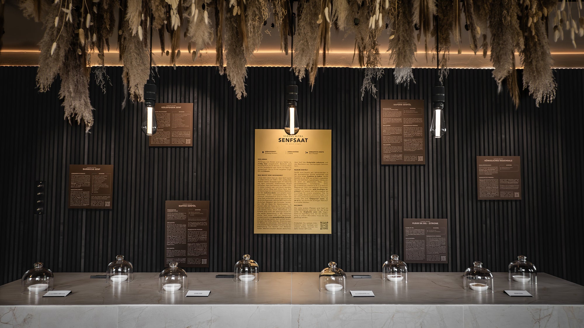 Varuna Mitra Showroom Flagship Store Aromatresen und Produktwand mit Trockenblumen an der Decke